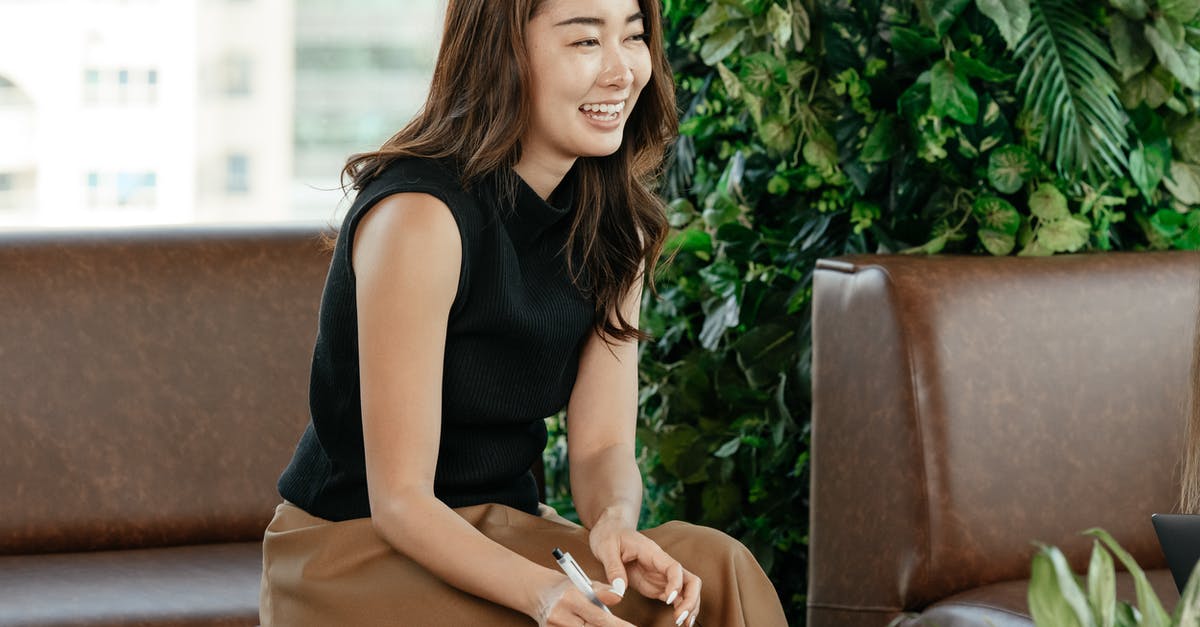 What would Frank Underwood's strategy be if he had been appointed Secretary of State? [closed] - Cheerful Asian woman in elegant outfit on leather sofa