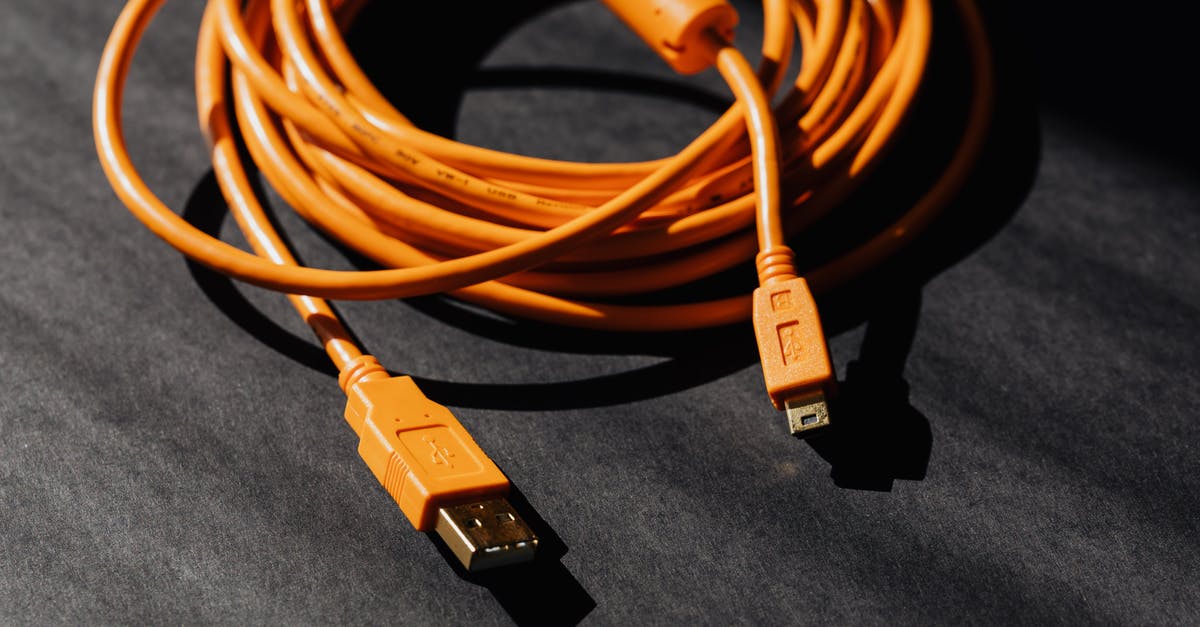 What year does Cable come from? - From above of orange usb to micro usb cable twisted into ring placed on black board