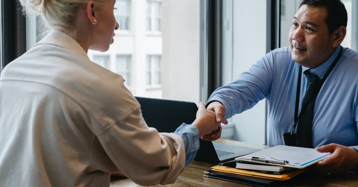 When can companies (or other entities) be directly referenced? - Ethnic businessman shaking hand of applicant in office