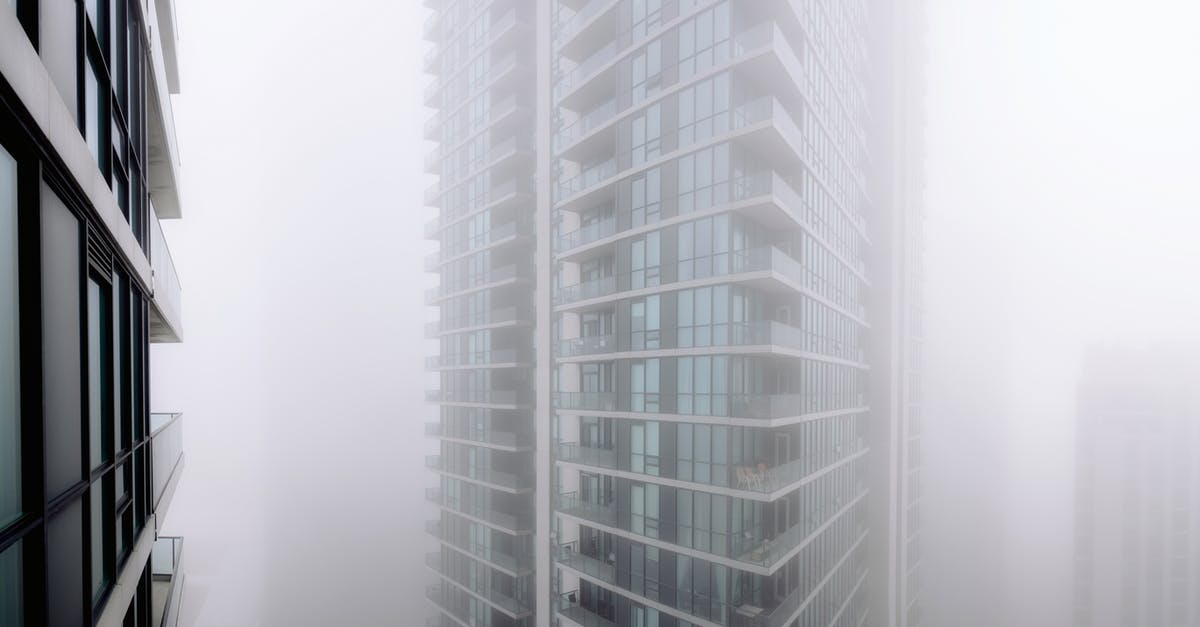 When did they become invisible? - Contemporary residential building with balconies covered with thick fog located on street of modern city with houses in overcast weather