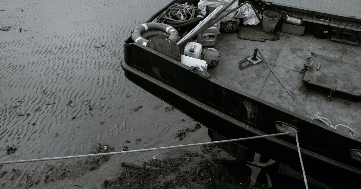 Where did the 2nd Ooze canister come from? - From above of black and white aged boat with stack of lifebuoys and ropes moored on shore of rippling sea on cloudy day