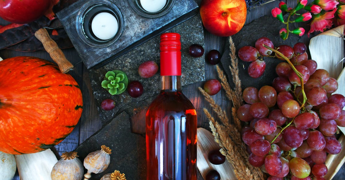 Where did the wheat actually come from? - Clear Glass Wine Bottle Surrounded by Fruits Top View Photography