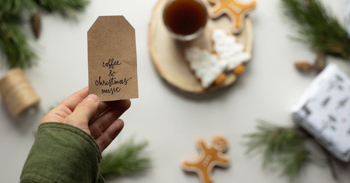 Where did they get the background music for "The Magic Roundabout"? - Selective focus of male hand holding brown paper tag with sign Coffee And Christmas Music and Christmas composition on background