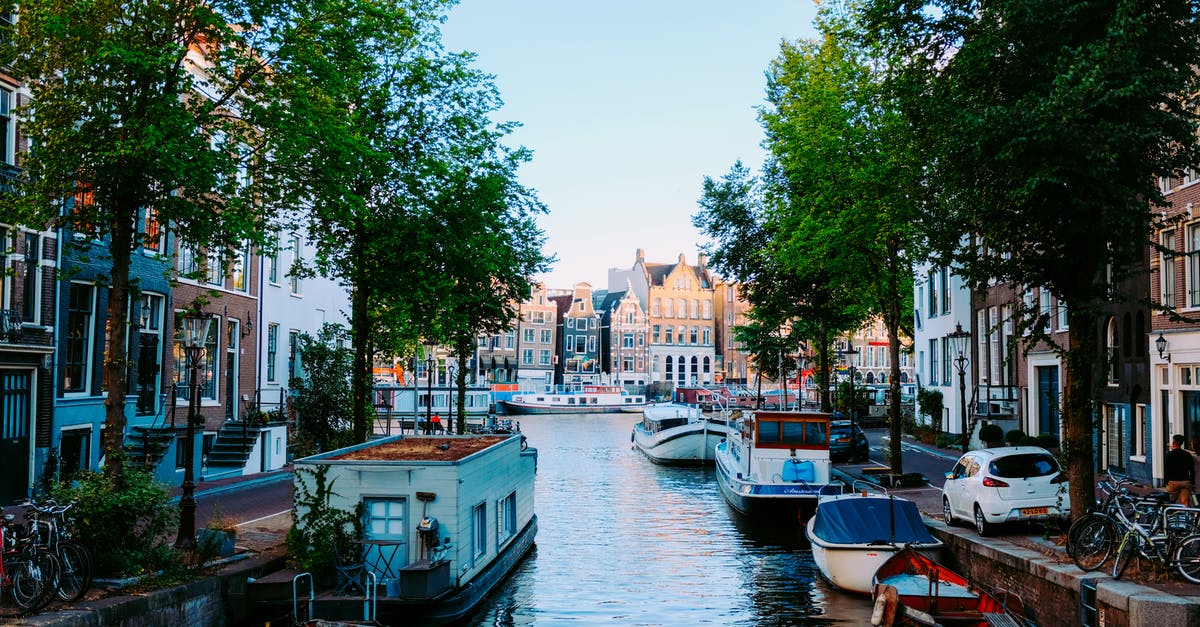 Where was this Old Amsterdam commercial filmed, exactly? - Peaceful scenery of Amsterdam streets with typical houses against channel with moored boats on clear sunny day