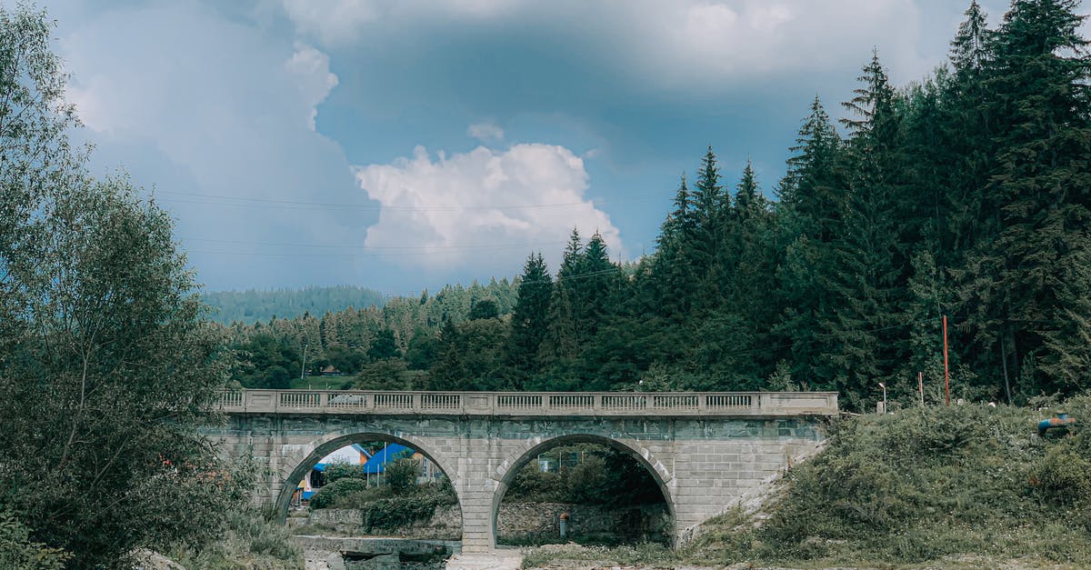 Which episodes of Flash cross over with Arrow? - Arched stone bridge over calm river