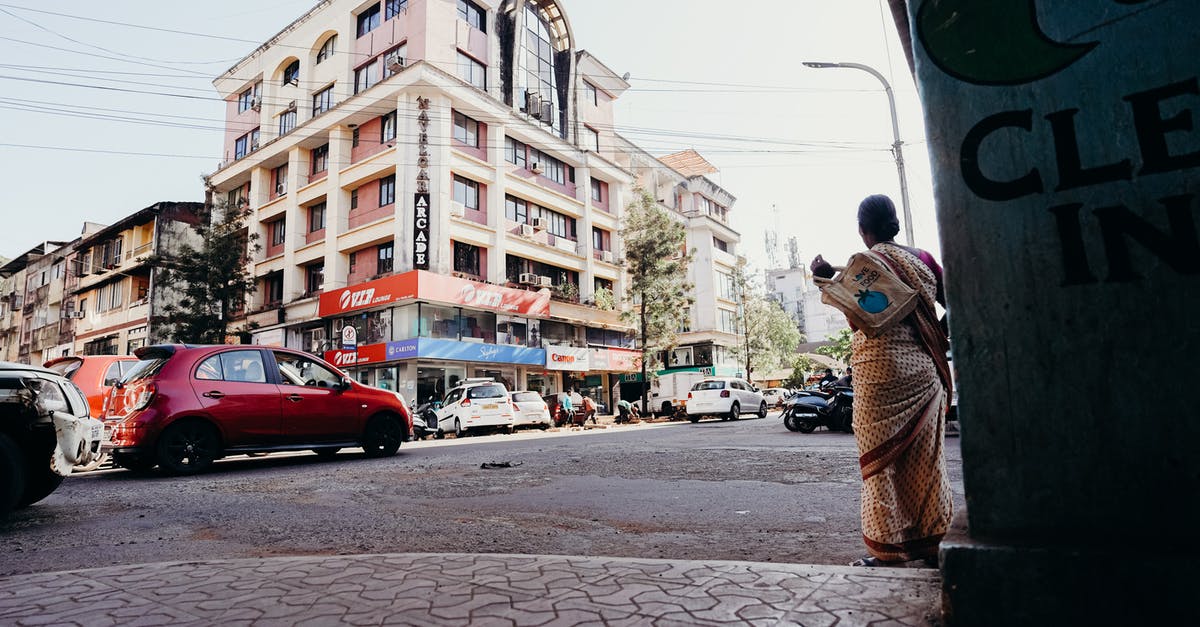 Which Indian female boxers' stories was "Saala Khadoos" inspired from? - Man in Brown Jacket Standing on Sidewalk Near Cars and Buildings