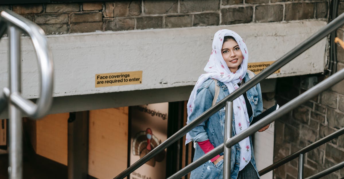 Which Skywalker rises in The Rise of Skywalker? - Charismatic woman in casual wear and headscarf with notebook in hand rising on stairs from underpass and looking at camera while having walk in city