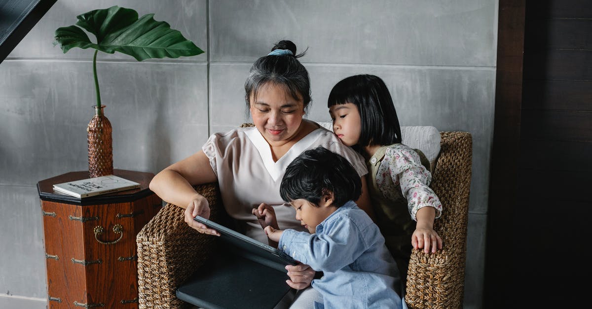 Which years are referred to as "Generation 1" in the original Transformers cartoon series? - Calm Asian woman sitting with kids and using tablet while spending time together at home