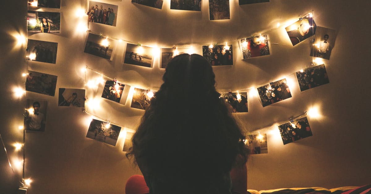 Who are these people in the pictures in Adam's room? - Woman Watching Photo Collection With String Lights
