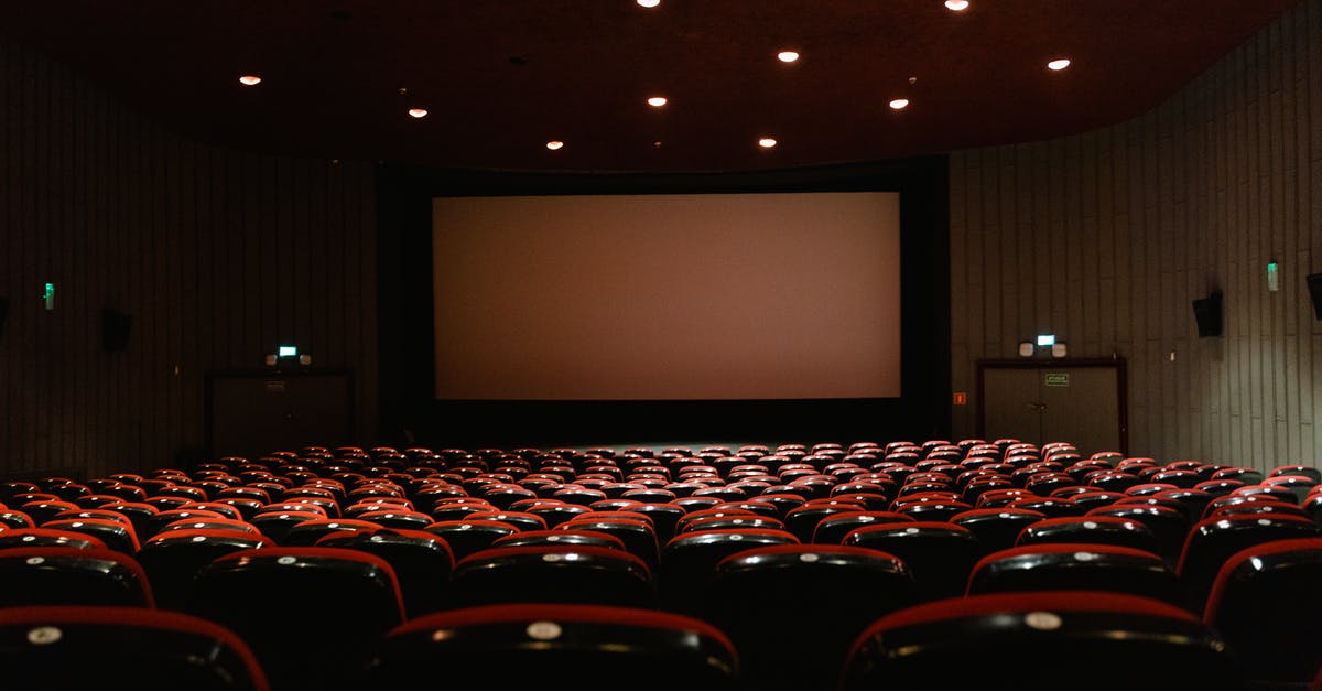 Who decides the genre of a movie? - People Sitting on Red Chairs