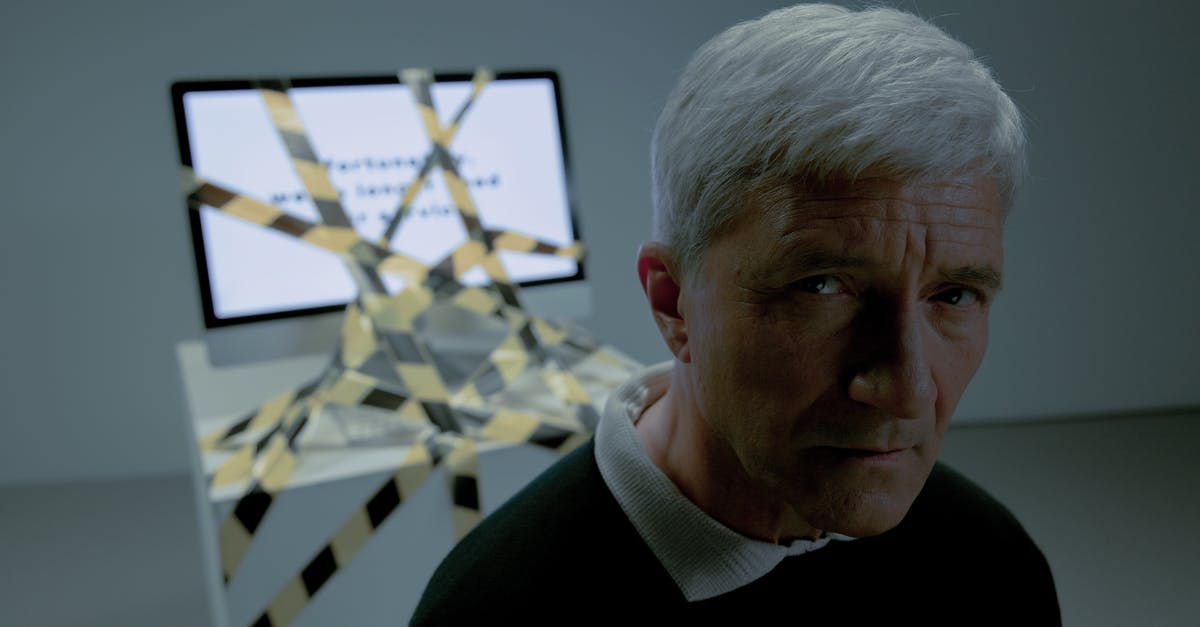 Who fired the shot and what is the symbolism in firing shot right next to Lucas at the end of the movie? - An elderly man looking at camera and computer tied with a black and yellow tape behind him