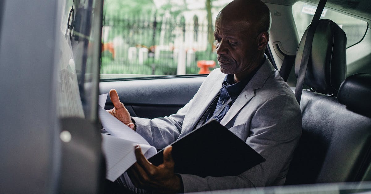 Who is responsible for sabotaging the car? - Focused black responsible man working with papers in car
