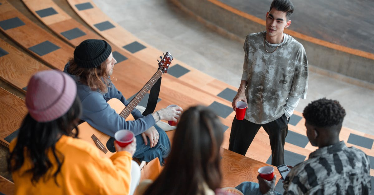 Who is talking to Claudia in the end shot? - Boy in Gray Sweater Playing Guitar