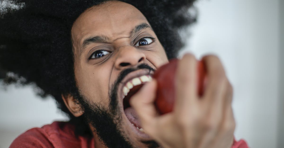 Who likes to bite the big one? - Man in Red Shirt Holding Red Apple