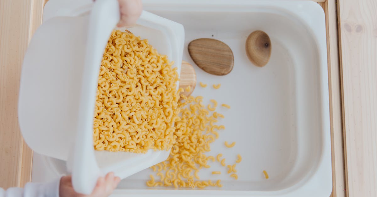 Who put the key in the box, and how did they get it? - Unrecognizable crop kid adding raw pasta to white container