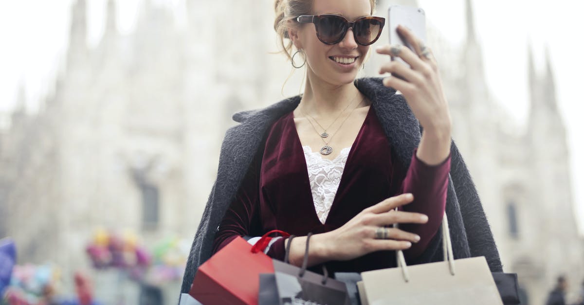 Who really takes the jewels? - Woman in Maroon Long-sleeved Top Holding Smartphone With Shopping Bags at Daytime