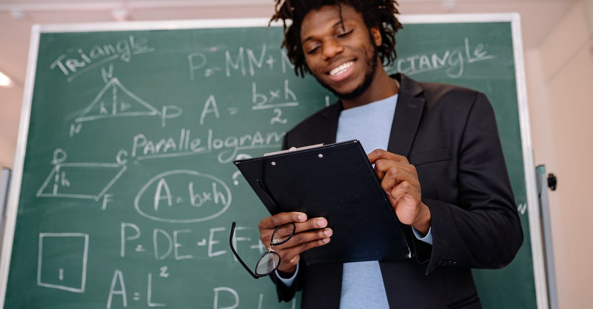 Who wrote the School of Rock blackboard? - Woman in Black Blazer Holding Black Tablet Computer