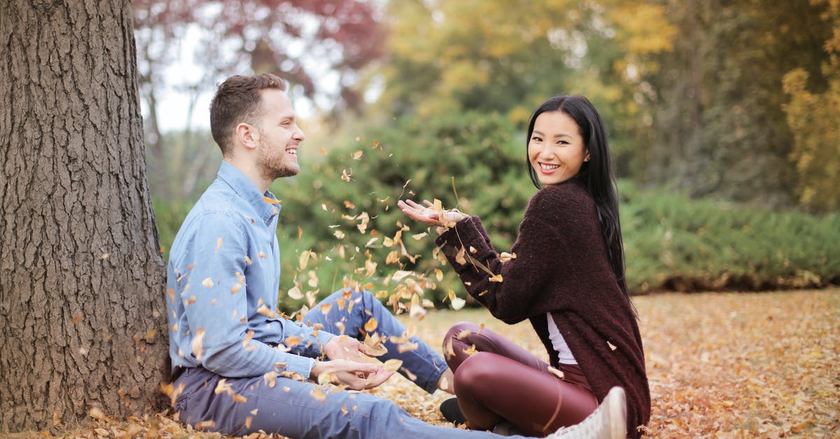 Why are children laughing heard at the very end of Veronica Mars Season 2 Episode 17? - Side view of cheerful couple in casual clothes sitting in park and having fun while scattering dry leaves on autumn day