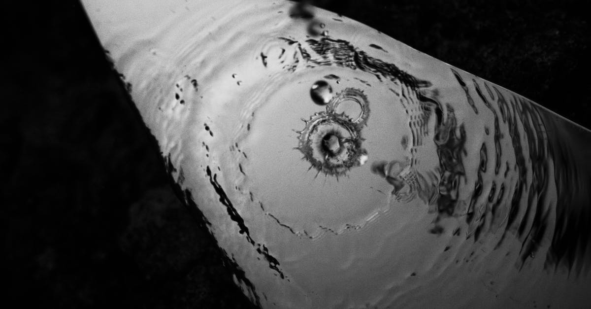 Why are rainy scenes in Thelma & Louise sunny? - Black and white from above of puddle with circles and falling droplets on street with shadow in evening time