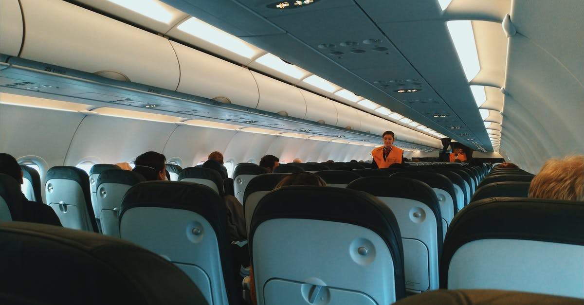 Why are the crew members in Passengers locked in? - Inside of modern airplane cabin with passengers sitting on comfortable seats and cabin crew standing at passageway
