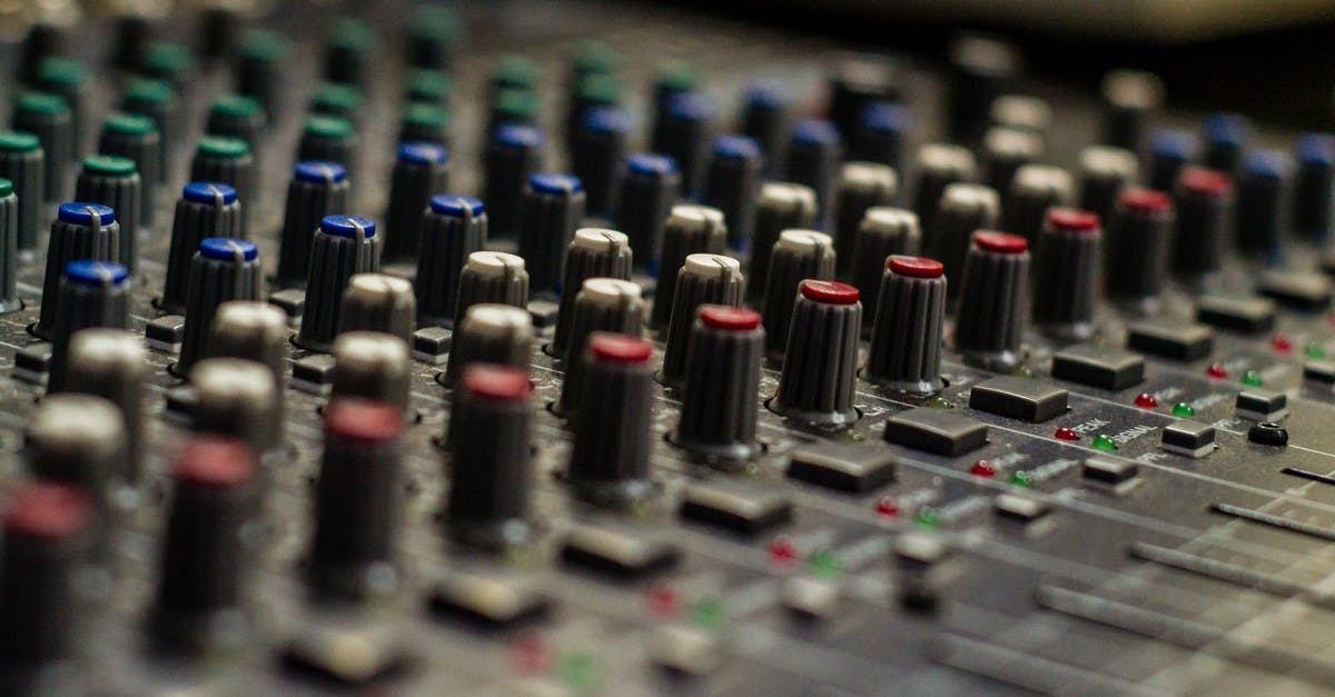 Why are there different audio levels for different languages? - Sound mixer with rows of knobs in recording studio