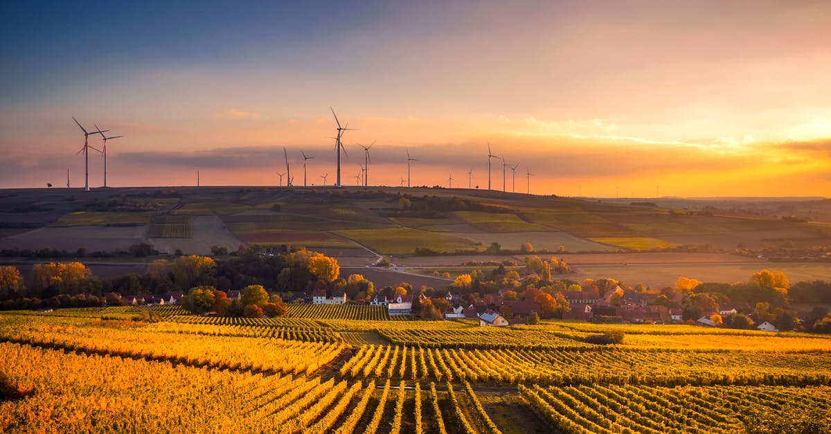 Why are turbines attached to the buildings? - Scenic View of Agricultural Field Against Sky during Sunset