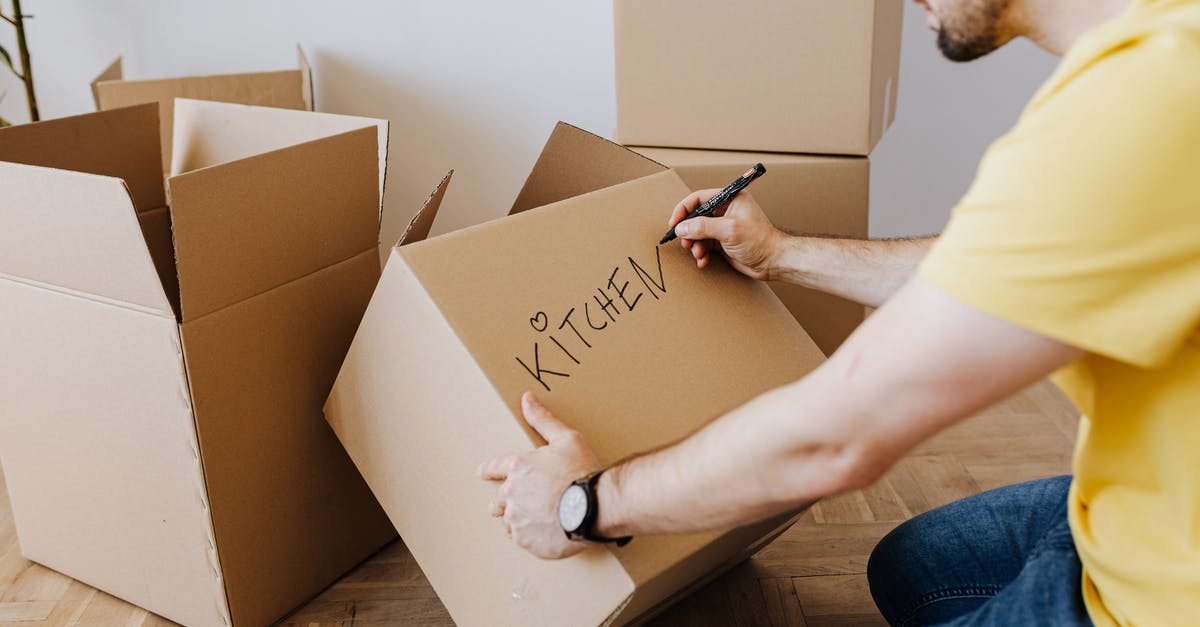 Why aren't Kaylie and Tim packing the things and leaving the house since the experiment is impossible to complete? - Crop man with pile of cardboard boxes for packing belongings