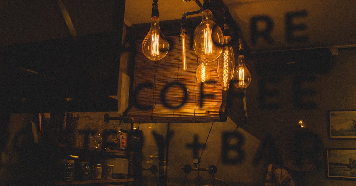 Why bother hanging a disturbing picture in your office? - Through bar window view of glowing light bulbs in dark interior with cafeteria information on glass