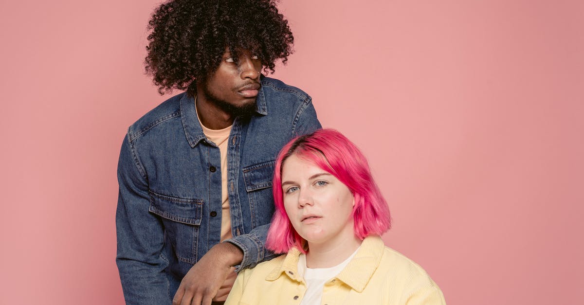 Why couldn't they live with different appearances in "What happened to Monday"? - Young black man leaning on shoulder of woman with dyed hair sitting against pink background