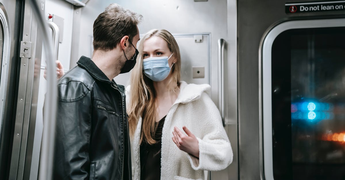 Why did Brian stand in front of the subway train the first time he took NZT? - Anonymous couple in warm clothes and protective masks standing in train in subway and talking while looking at each other