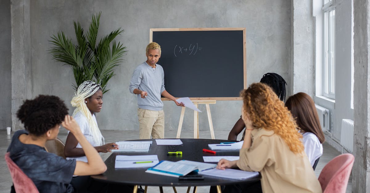Why did Donnie ask that question? - African American student explaining mathematic equation to diverse classmates while doing homework together in spacious room