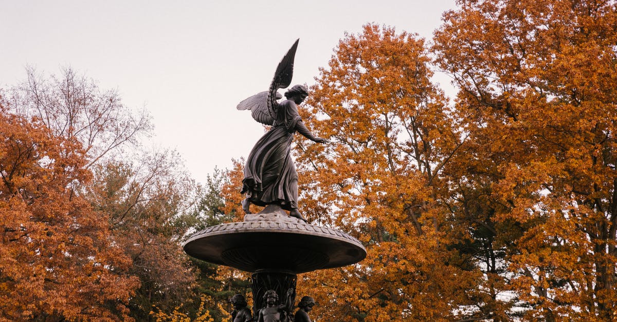 Why did Dr. Manhattan choose the hydrogen atom for the symbol on his forehead? - Statue of angel in peaceful autumn park