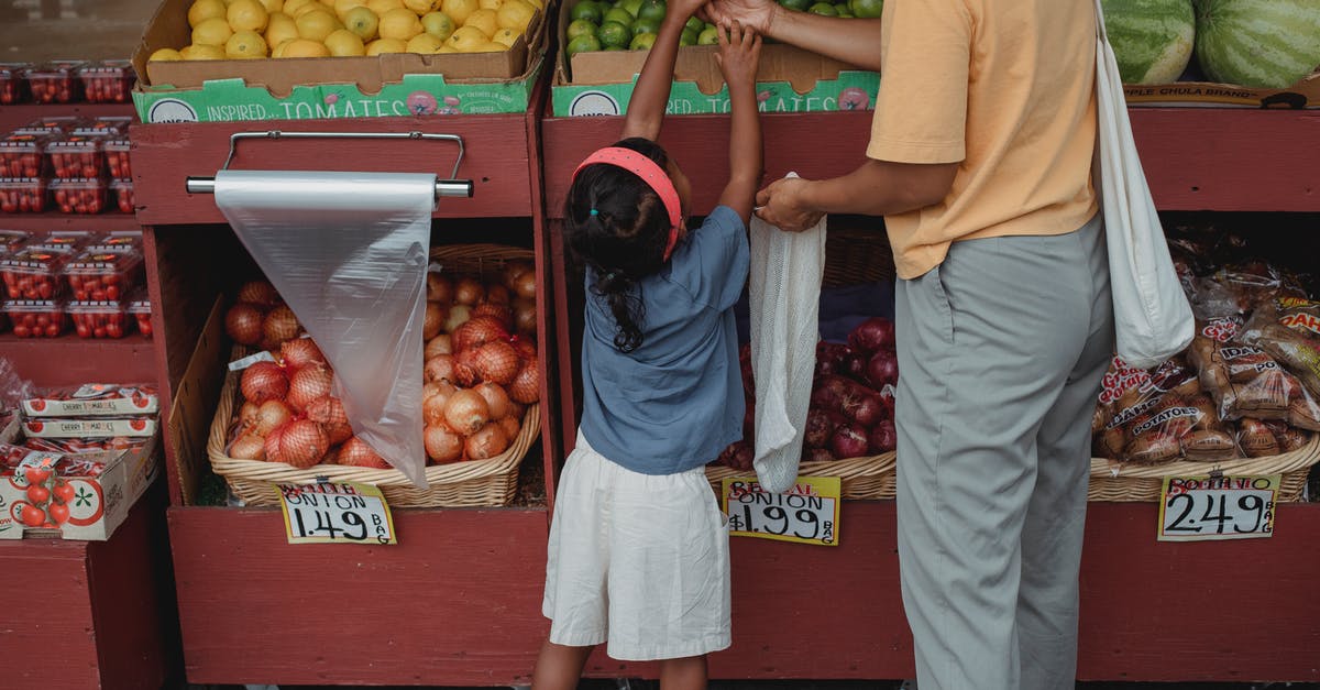 Why did Frank Castle save the kid during the robbery? - Ethnic woman choosing fruits with daughter in market