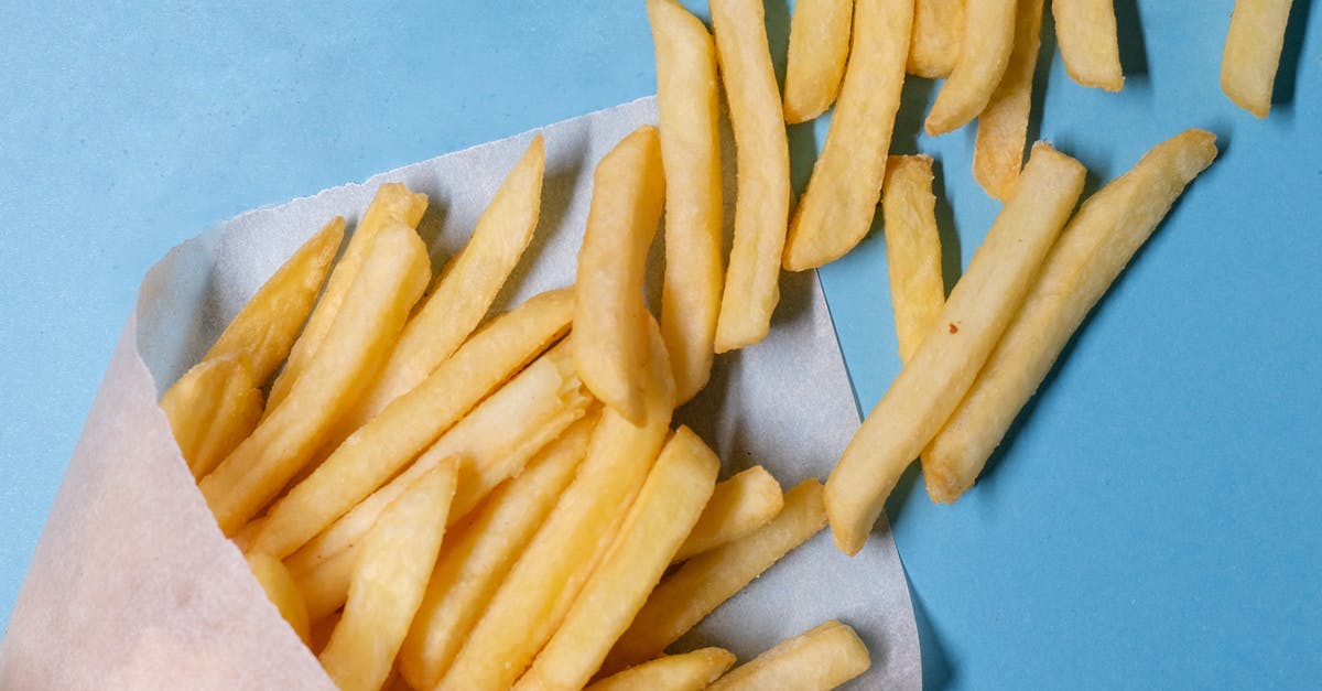 Why did French Canadians dub Slap Shot in Canadian Quebec French instead of Canadian French? - Top view of tasty french fries in paper placed on blue table in light studio