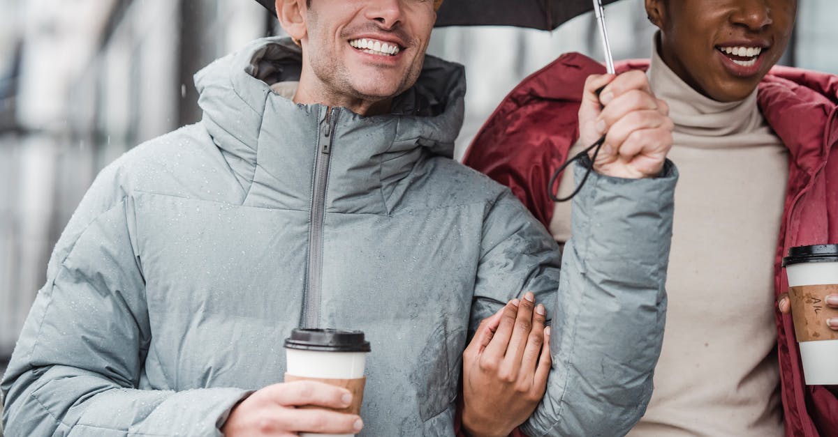 Why did Jacob need to walk into the rain to get his memory erased? - Diverse cheerful couple with coffee and umbrella walking