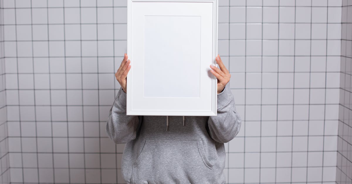 Why did Kayla hide this photo on the desk? - Faceless person covering face with empty photo frame