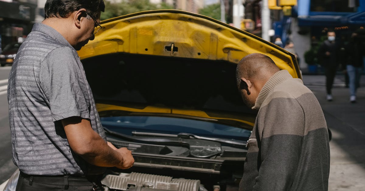Why did Michèle damage Richard's car? - Ethnic mechanic checking car standing near man