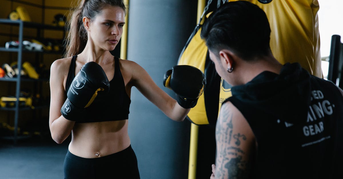 Why did Mike hit Walt when he asked for Mike's help in killing Fring? - Anonymous personal trainer helping sportive female in gloves with punching technique near boxing bag during workout in light modern gym