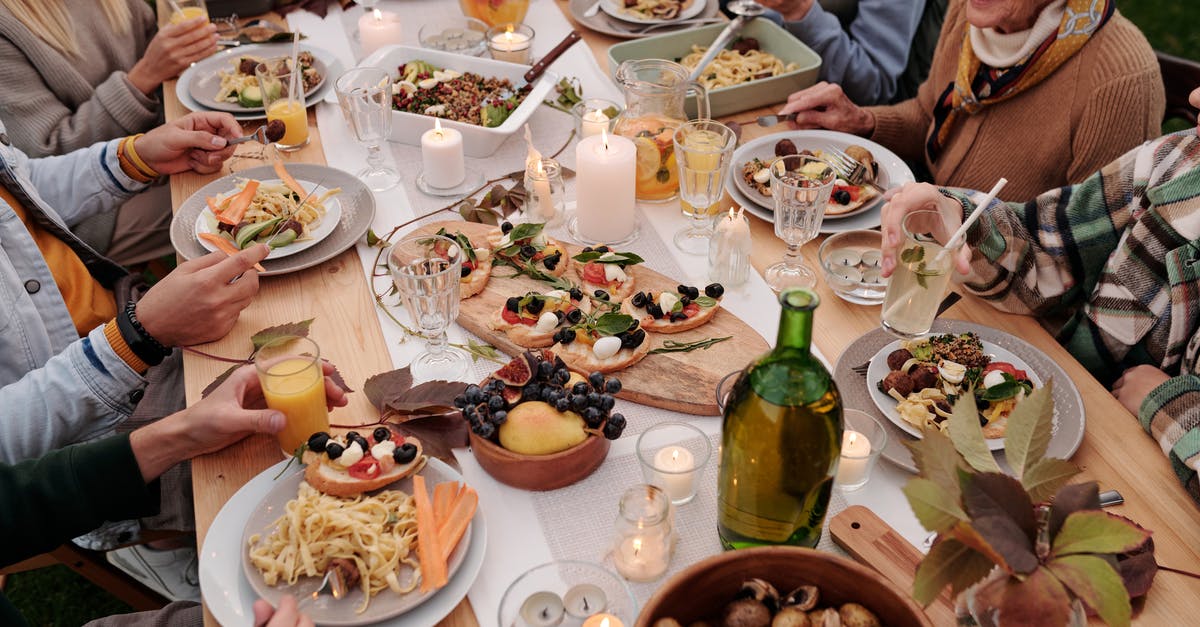 Why did Olivia's family celebrate Thanksgiving? - From above crop people enjoying festive dinner with snacks at garden table with candles burning