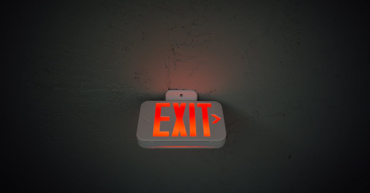 Why did Rob Lowe exit The West Wing? - From below of illuminated exit sign hanging on gray concrete ceiling in dark room
