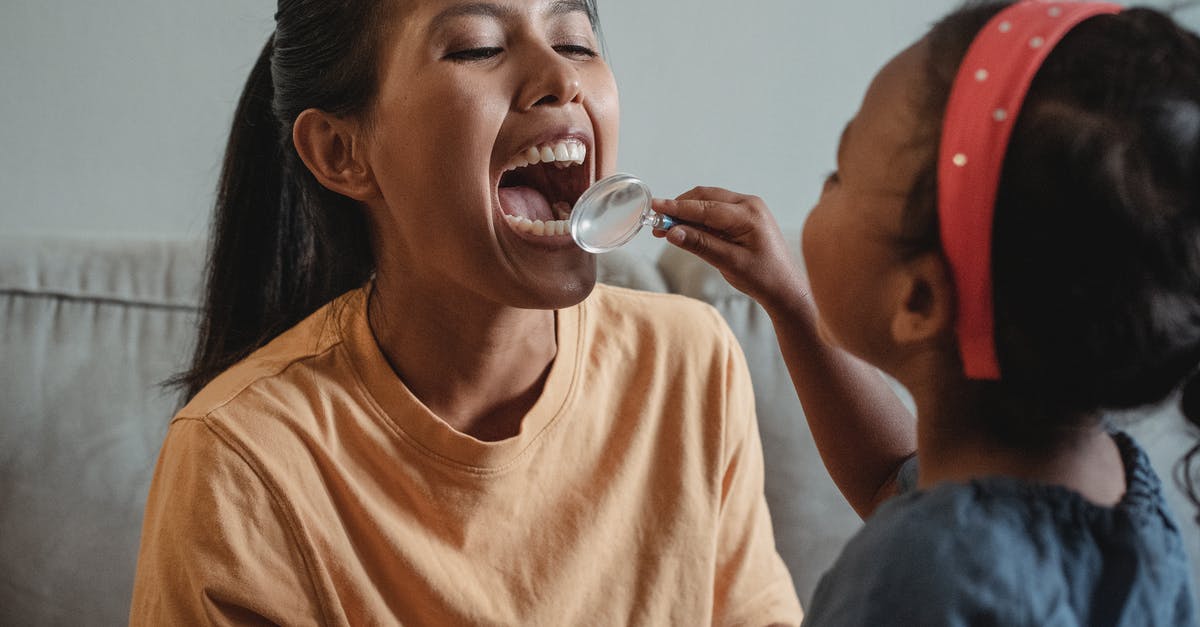 Why did the Arikara spare Glass? - Crop Asian mother and daughter playing dentist game together