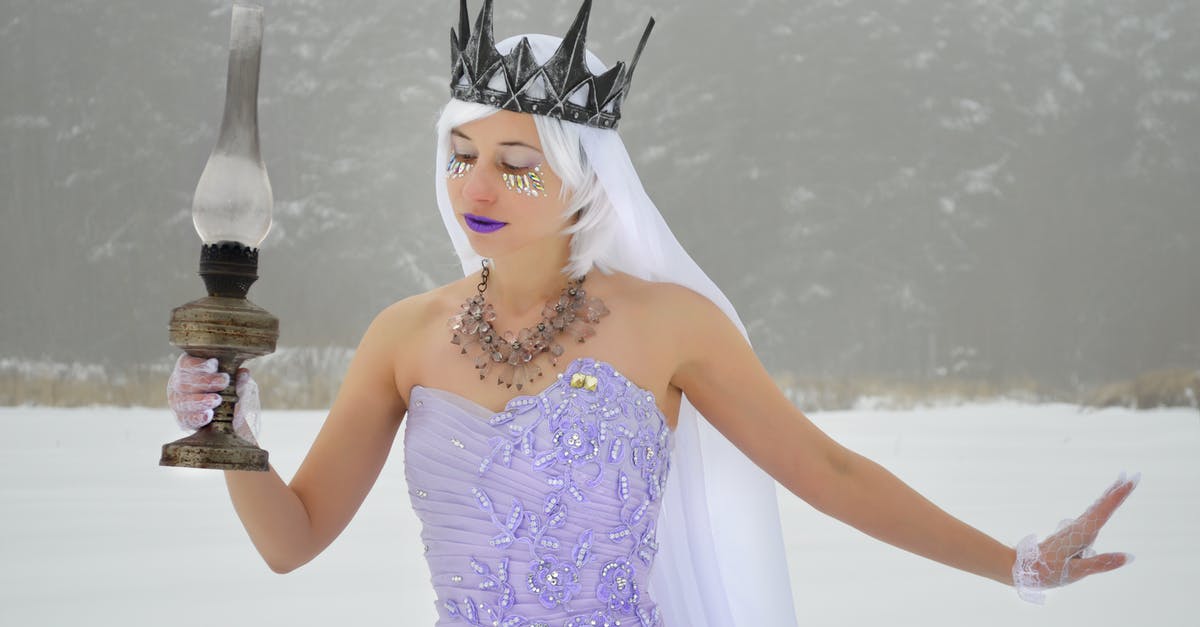 Why did the Fairy Queen have to die for a poor deal? - Elegant young woman wearing purple dress and crown with white veil and gloves with old kerosene lamp in hand on snowy meadow near woods
