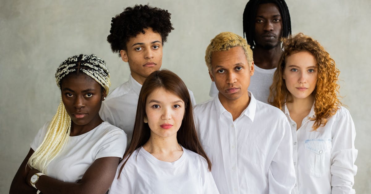 Why did the Front Man join the organization? - Serious diverse multiracial people standing close together representing concept of unity  and looking at camera against gray background