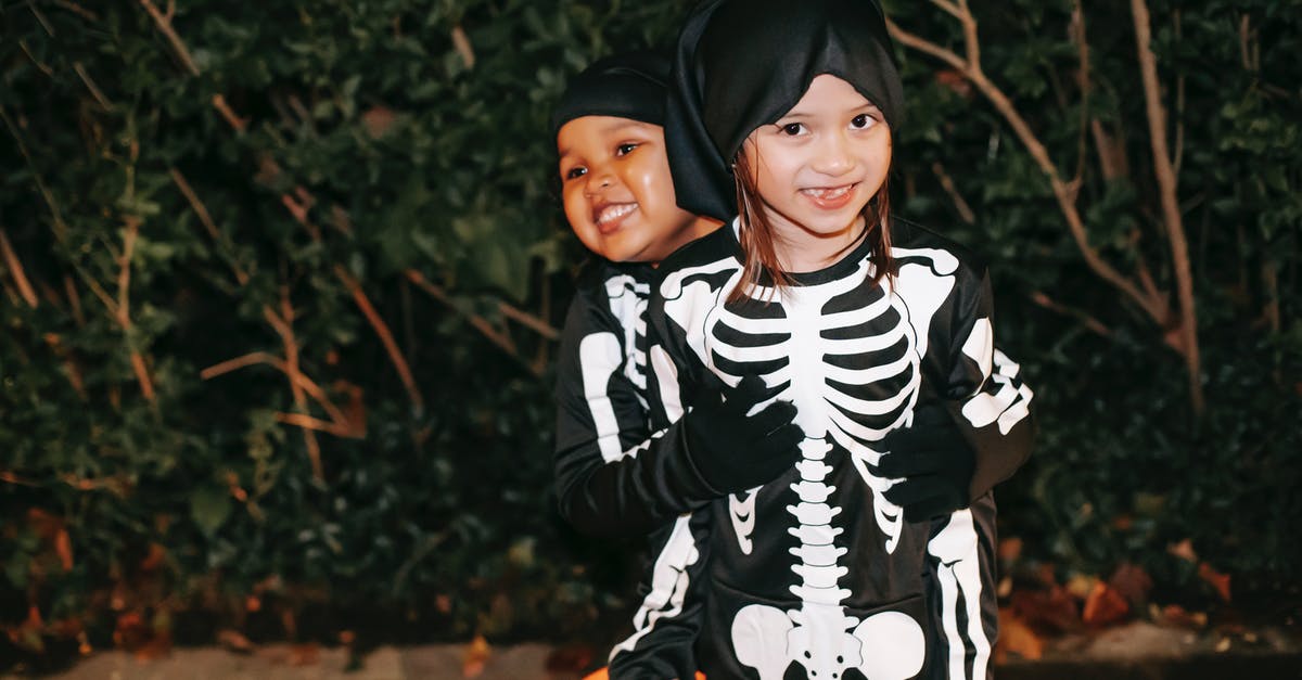 Why did the Jennings even have kids? - Happy best multiethnic female friends in Halloween costumes embracing against plants in town at dusk