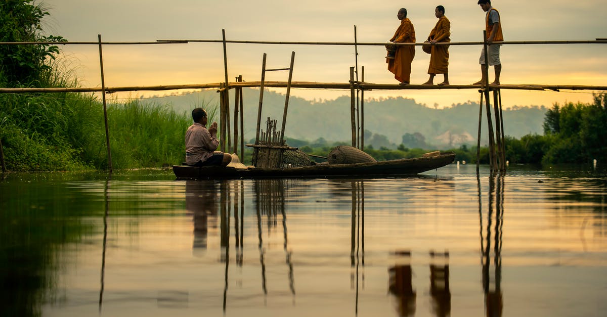 Why did the monk take a boat, when he could just have jumped over the river? - Shallow Focus Photo of People Crossing A Bridge