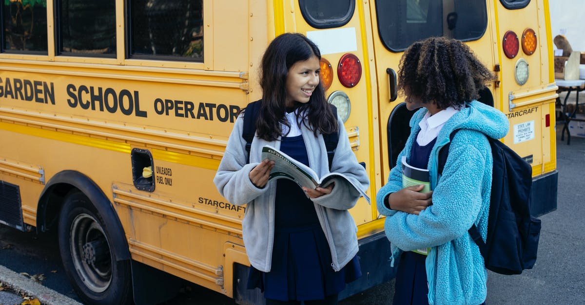 Why did the Queen chase the school bus? - Happy multiracial classmates with backpacks standing near yellow school bus and communicating after school while looking at each other