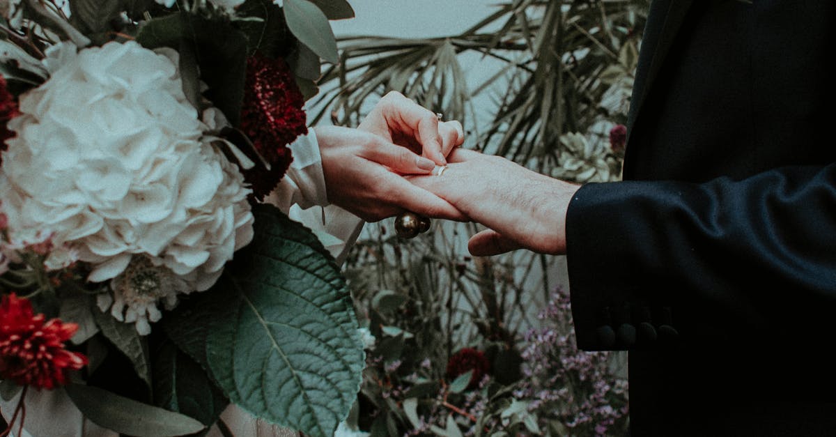 Why did the ring affect Frodo so much and not Bilbo? - Crop bride with gorgeous flower bouquet putting wedding ring on finger of groom on wedding ceremony