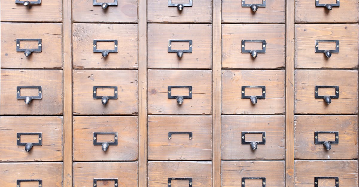 Why did they keep repeating the same conversation? - Background of wall full of many similar aged shabby vintage wooden drawers with metal round handles