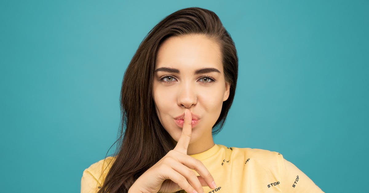 Why didn't Arania Exumai harm Ron in the Chamber of Secrets? - Portrait Photo of Woman in Yellow T-shirt Doing the Shh Sign While Standing In Front of Blue Background
