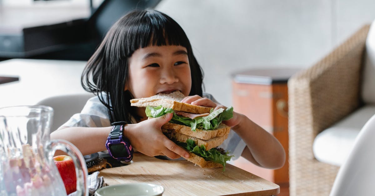 Why didn't Audrey (Jerry's girlfriend) eat the apple pie? - Asian child sitting at wooden table during breakfast and eating tasty sandwich with lettuce leaves